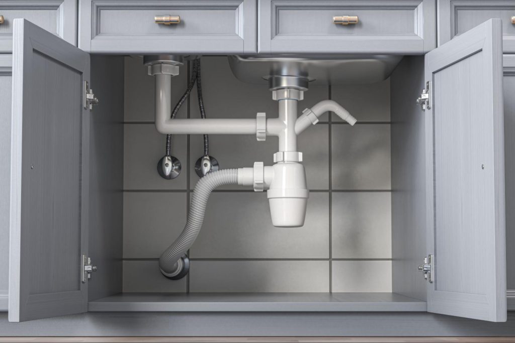 Cabinets opening up to a sink, pipes, and drainage.