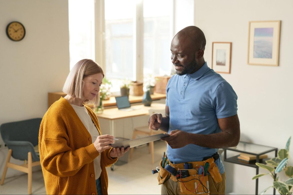 Repair man speaking to a woman. 