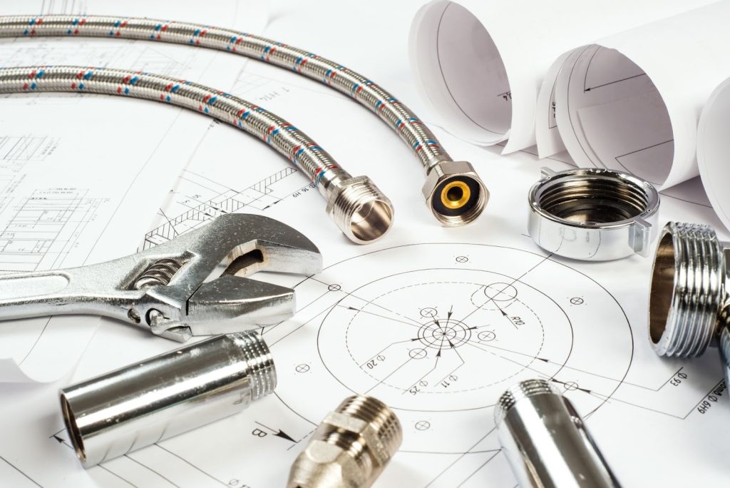 Plumbing materials arranged alongside construction blueprints