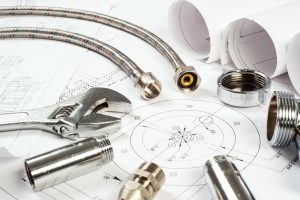 Plumbing materials arranged alongside construction blueprints