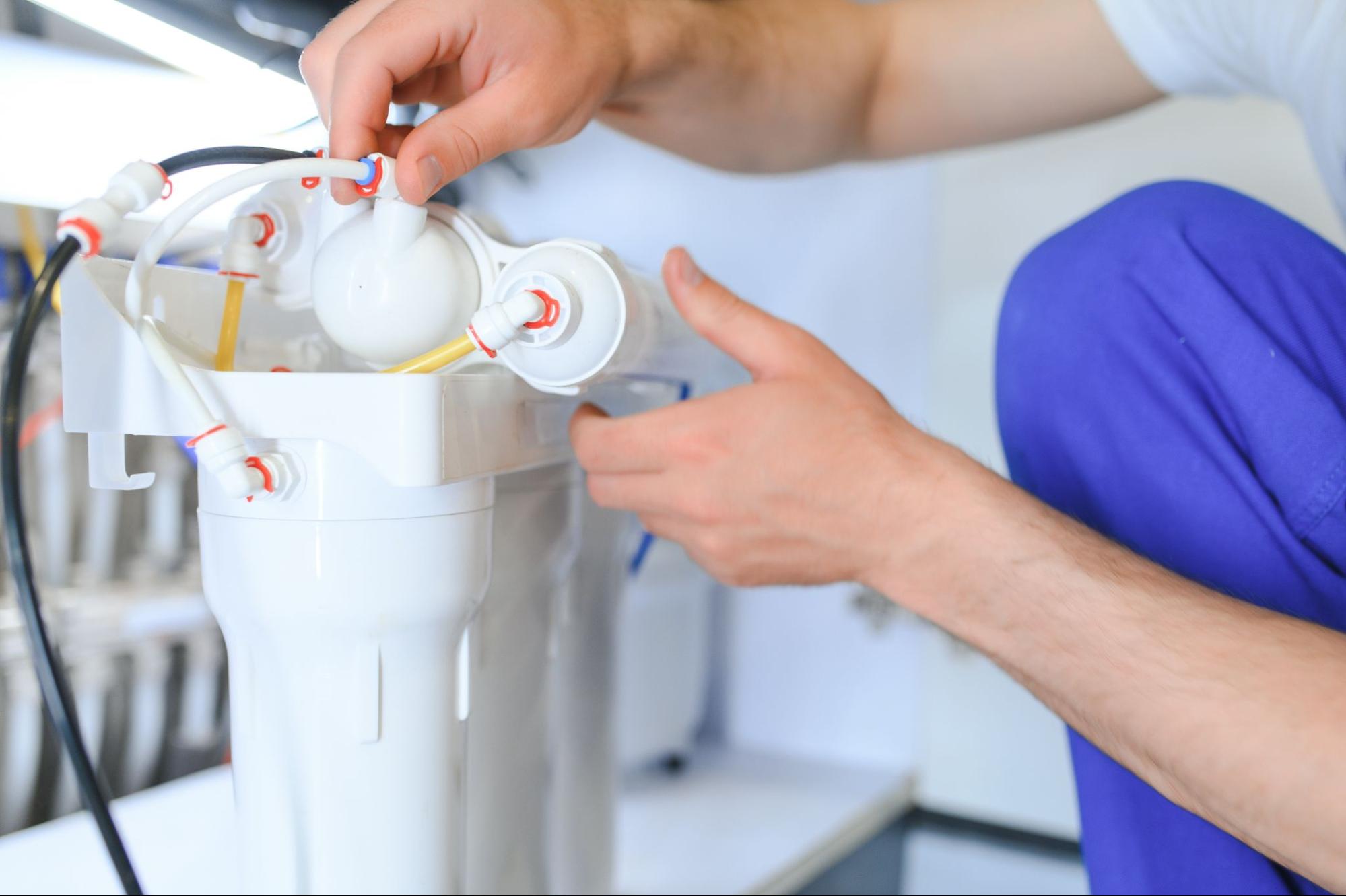 A close-up of a plumber replacing a home water filter.