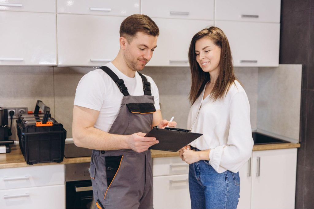 A technician presents the repair cost estimate to a female homeowner.