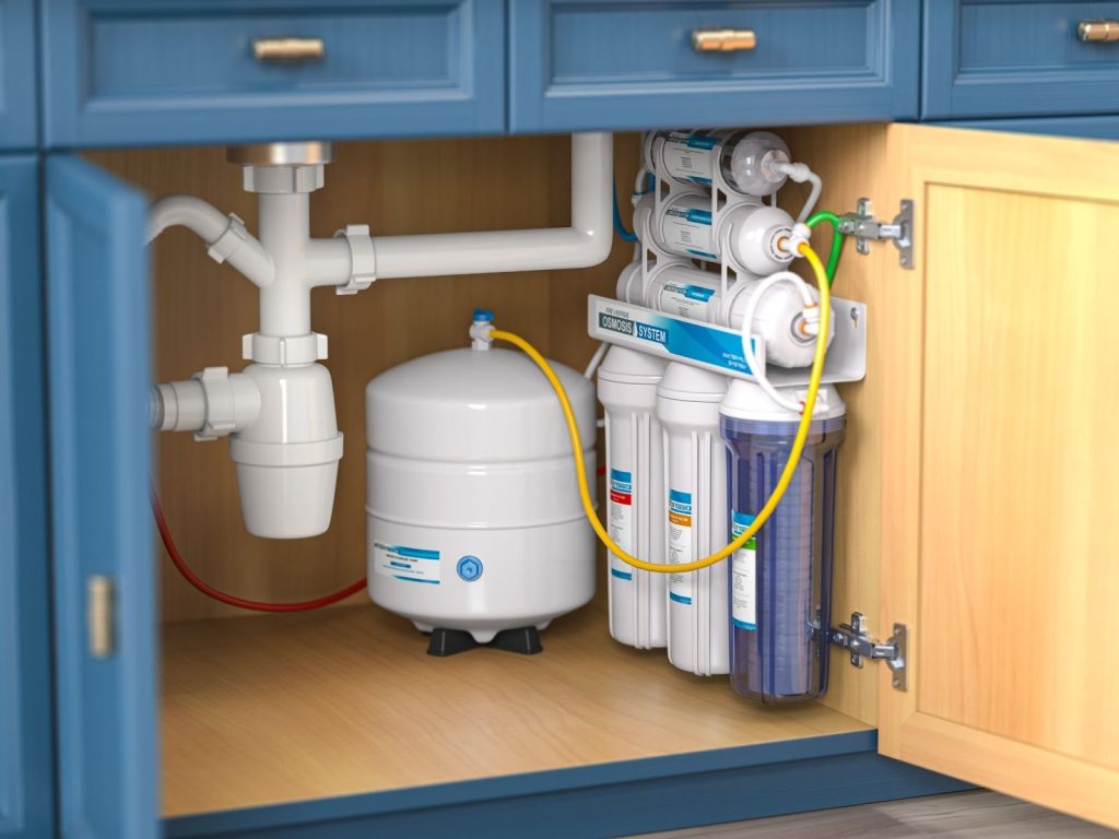 An image of a water softener system underneath a sink.