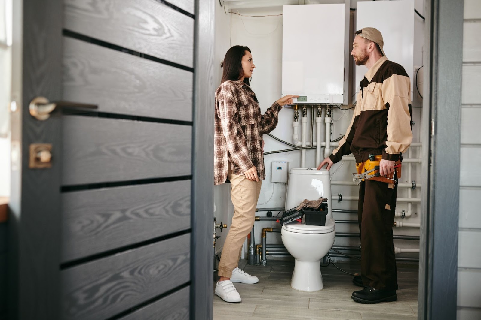 A local plumber explains a bathroom plumbing issue to a homeowner during an in-home inspection.