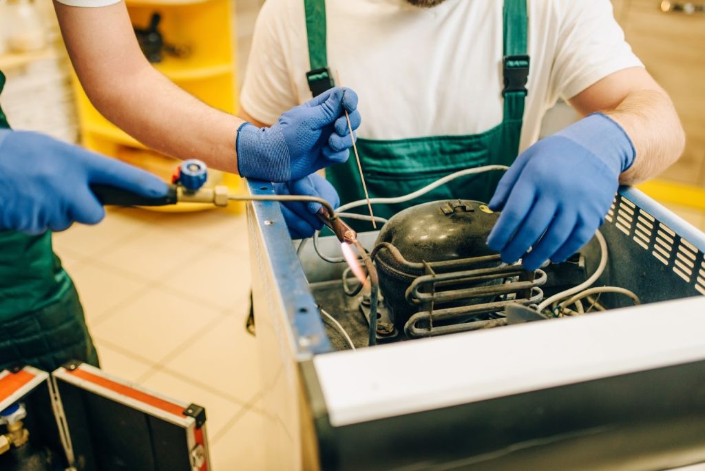 Technicians servicing a malfunctioning heat pump during repair